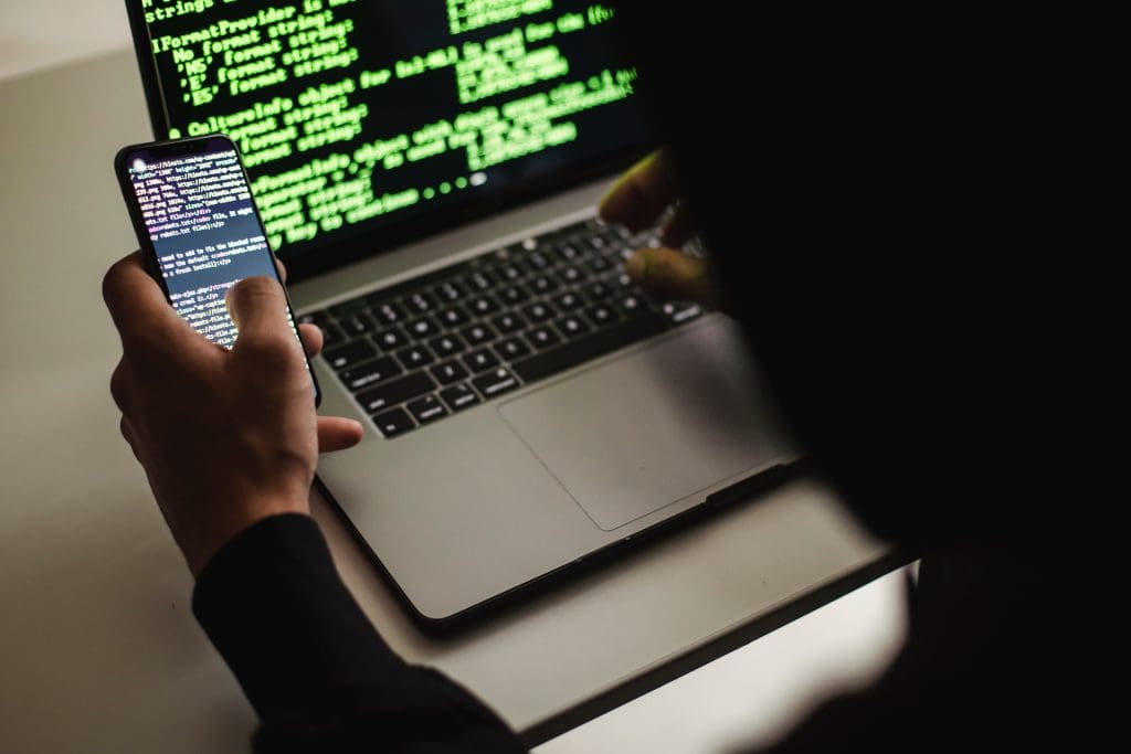 silueta media de una persona usando un celular y un computador portátil